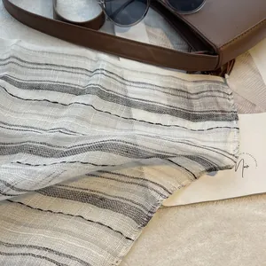 Détail d'un foulard en lin rayé respirant avec tissage texturé et style français