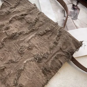 Close-up of the vintage brown tote bag featuring unique frayed edge texture and leather strap