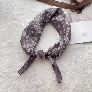 Detail of purple paisley cotton bandana with intricate white floral patterns on white background
