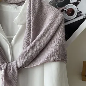 Detail of light purple pleated scarf with delicate wavy lace edges on white shirt