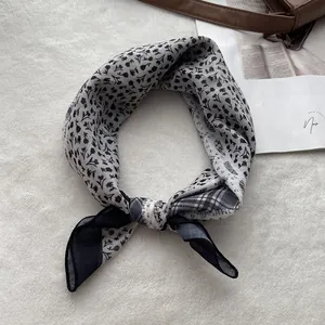 Detail view of cotton-linen feel neck scarf with elegant black and white floral pattern