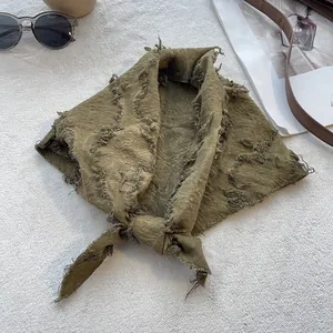Detail of olive green cotton linen scarf with distressed frayed edges and fringe texture