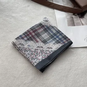 Detailed close-up of retro plaid and floral patchwork cotton linen scarf on plush mat