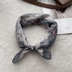 Close-up of lightweight floral cotton linen scarf with vintage plaid pattern on plush background