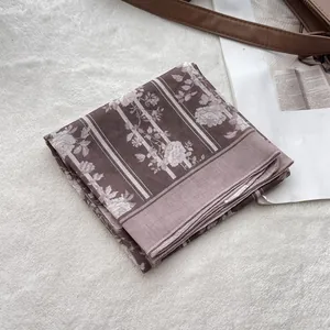 Detail of retro floral cotton square scarf with rose patterns and striped rolled edges