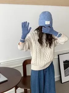 Close-up of blue knitted touchscreen gloves and matching beanie with knit patterns