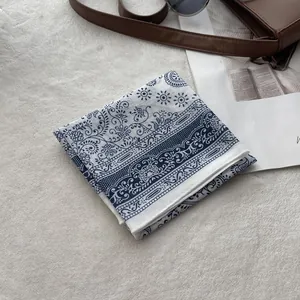 Close-up of blue and white paisley linen scarf with detailed stitching and soft texture