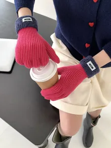 Detaillierte Textur pinker Strickhandschuhe mit grauen Rippbündchen und blauem Label