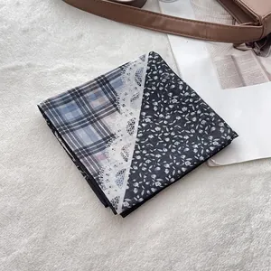 Detail of cotton bandana with blue plaid, white lace, and floral patchwork texture