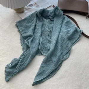 Detailed view of the turquoise cotton linen scarf featuring pleated texture and wavy edges