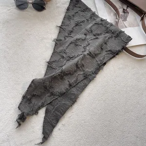 Close-up of dark gray crinkled cotton linen scarf featuring raw frayed edge details