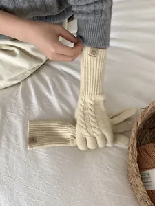 Close-up of cable knit texture and brown woven label on warm wool blend gloves