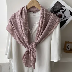 Detail of lavender pleated cotton linen scarf with fine overlock stitching on a white shirt