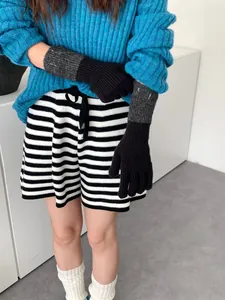 Detailansicht der Strickhandschuhe kombiniert mit blauem Rippstrickpullover und Shorts