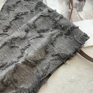 Close-up of beige tie-dye cotton linen scarf with distressed fringe and vintage texture