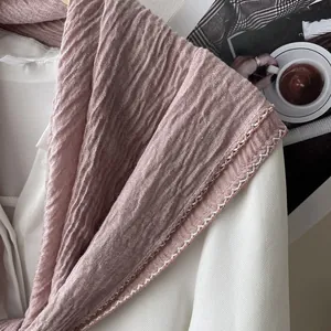 Detail of dusty pink pleated scarf featuring delicate white wavy stitched edges