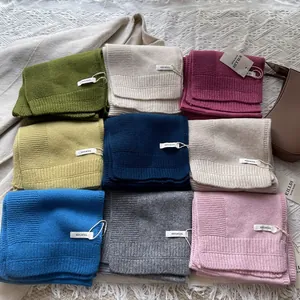 Detalle de bufandas de lana 100% en varios colores con tejido de punto acanalado y etiquetas