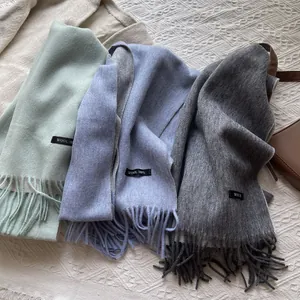 Detailed shot of 100% wool scarves with fringe edges and premium material labels