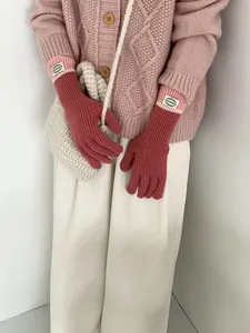 Detail of pink knitted touchscreen gloves with contrast cuffs and soft winter texture