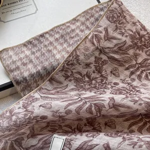 Close-up of floral scarf detail showing houndstooth pattern and delicate stitched edges