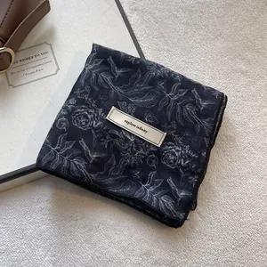 Detail of floral cotton linen scarf with 'explore infinity' tag and vintage pattern