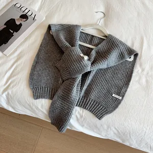 Chic milk-tea grey knit shawl wrap with waffle texture and ribbed edges on white bedding