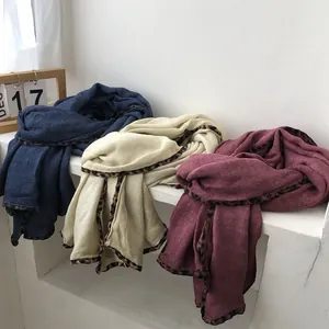 Detail of leopard print borders on blue, cream, and burgundy cotton linen scarves