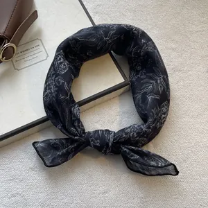 Detail of floral chiffon scarf with black and white botanical print and tied knot texture