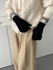 Close-up of knit gloves with striped cuffs and touch screen fingers for winter warmth