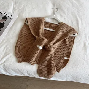 Detail of milk tea knit shawl showing thick waffle texture and chic tie straps