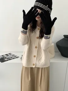 Detail of long black knitted touchscreen gloves with striped cuffs and logo patch