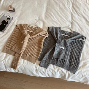 Chales de punto trenzado gris y caqui con lazos decorativos y texturas de rayas
