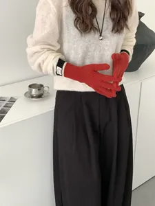 Detail of red winter knit gloves with touch screen fingers and striped ribbed cuffs