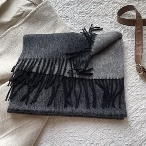 Detailed close-up of premium double-sided wool scarf featuring bicolor grey and black tassels
