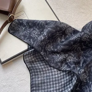 Detailed flat lay of a floral and houndstooth pattern cotton linen scarf with a leather bag