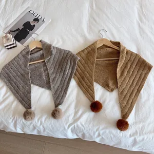 Winter knitted triangle scarf shawl set with soft pom-poms in grey and mustard yellow