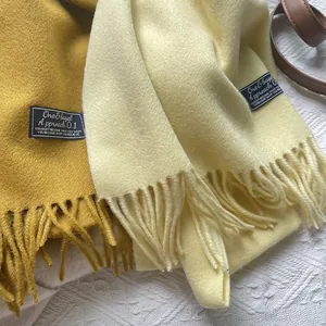 Detailed close-up of wool scarves with fringe edges and premium woven brand labels