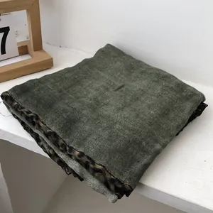 Detail of olive green cotton linen scarf with leopard print borders and soft brushed texture