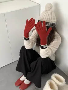 Detail showing red knitted winter touchscreen gloves with striped cuffs and ribbed texture