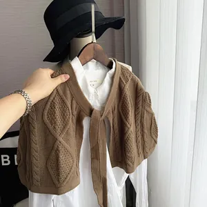 Detailed view of brown knit shawl with retro diamond pattern and twist texture