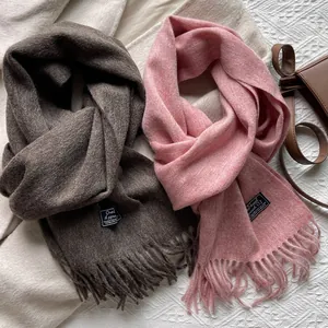 Detail of wool scarves with fringe in dark coffee and rose pink on knit background