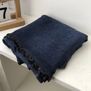 Detailed view of navy blue cotton linen scarf with black ribbon edge and textured fabric