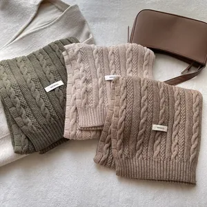 Three premium wool cable knit scarves in green, beige and brown with 100% wool labels