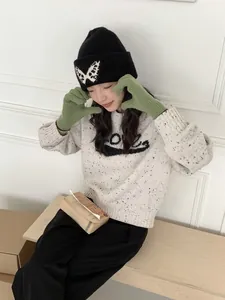 Green ribbed knit gloves for women styled in a cozy winter outfit detail view