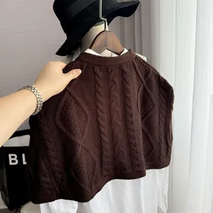 Detailed cable knit texture of dark brown vest layered over a crisp white shirt