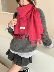 Nahaufnahme des rosa Wollschals mit Fransen und weißem Vintage-Webetikett
