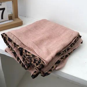 Detail of pink cotton-linen scarf featuring classic leopard print edges and woven texture