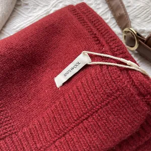 Detalle de bufanda roja de 100% lana pura mostrando la textura tejida y la etiqueta