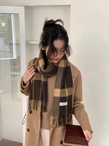 Detail of plaid cashmere scarf with long fringe and retro brown check pattern