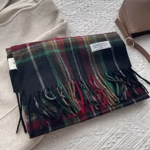 Close-up of wool plaid scarf with classic fringe detail and woven brand label